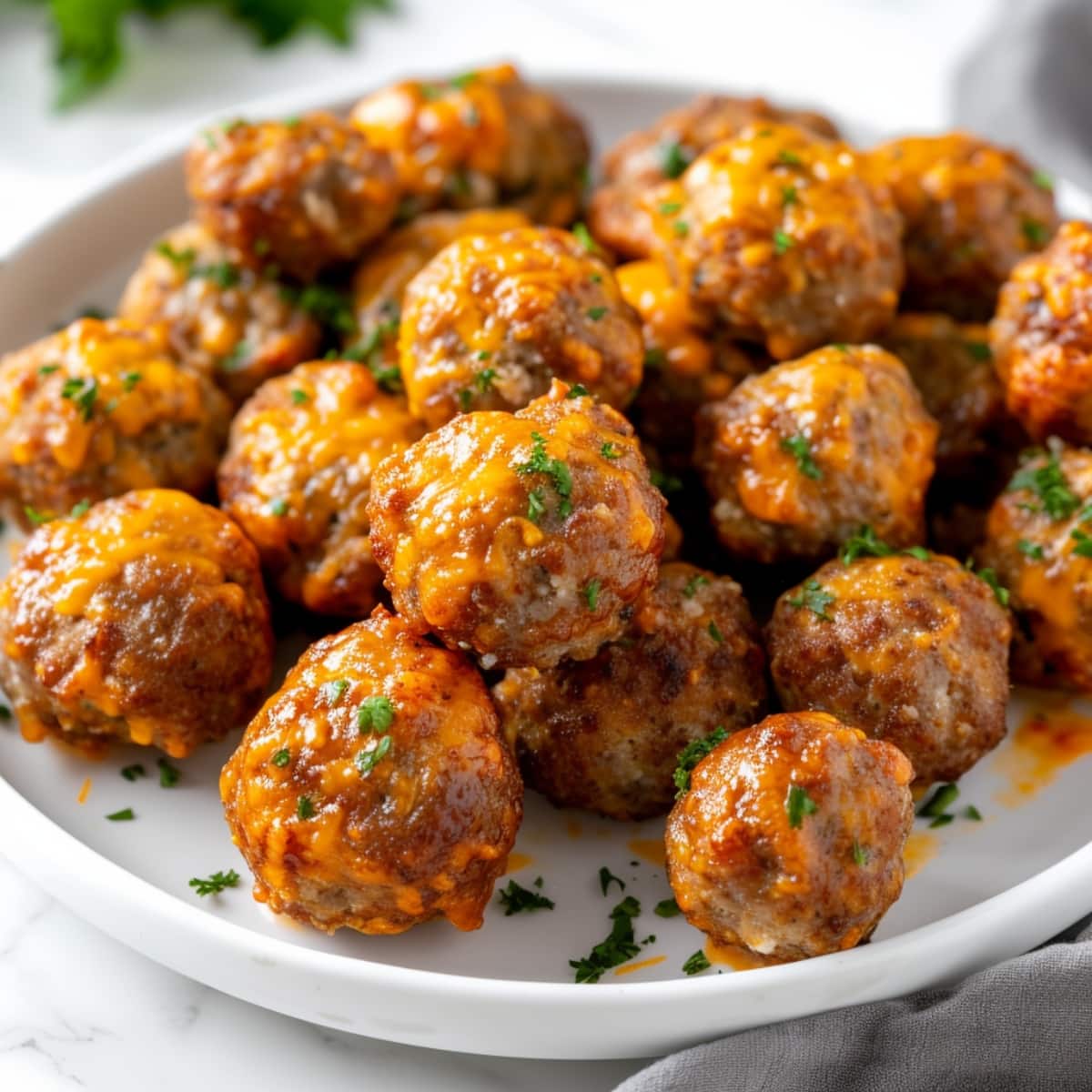 Bunch of Paula Deen sausage cheese balls on a white plate.