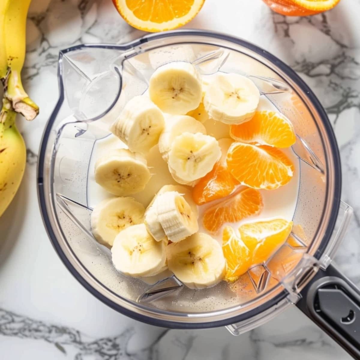 Blender with banana, orange and milk.