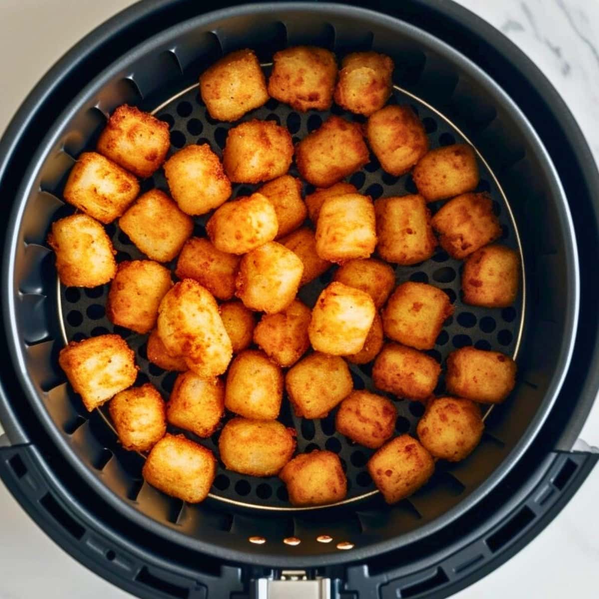 Tater tots inside an air fryer